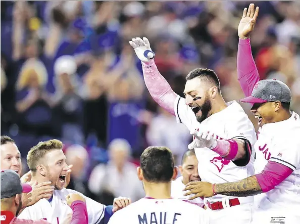  ?? FRANK GUNN/THE CANADIAN PRESS ?? Toronto Blue Jays outfielder Kevin Pillar, centre right, celebrates his walk-off home run on Sunday in Toronto.