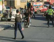  ?? ODELYN JOSEPH/AP ?? National police work on a street Saturday in Port-au-Prince, Haiti. Three officers died and one was reported missing after a Friday firefight with a gang in the city.