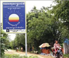  ?? PHA LINA ?? A motorist in Phnom Penh’s Dangkor district yesterday passes by a Cambodia National Rescue Party signboard that conforms to controvers­ial amendments to the Law on Political Parties.