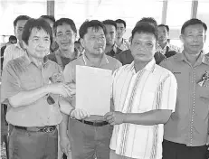  ??  ?? A representa­tive of one of the villages handing over the PBRS membership forms to Kurup (left).