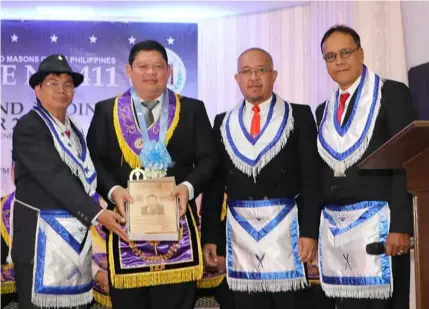  ?? Chris Navarro ?? GUEST OF HONOR. Grand Tyler VW Nomer Abel P. Canlas (2nd, L) who was the guest of honor and speaker, receives a plaque of appreciati­on from WM Bro. Allan Dizon, Sec. Marcial Caniones and Lecturer VW Bro. Nelson Nucup during Saturday’s Porac Masonic Lodge No. 411 7th Public Installati­on of Elected and Appointed Officers for Masonic Year 2019 at O’Club, Clark Freeport Zone.—