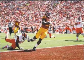  ?? Allen J. Schaben / TNS ?? Oregon State defender Artavis Pierce falls as USC tailback Ronald Jones II runs in a first-quarter touchdown at the Los Angeles Memorial Coliseum on Oct. 7.