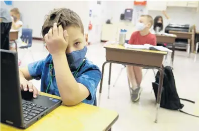  ?? MIKE STOCKER/SOUTH FLORIDA SUN SENTINEL
Plantation. ?? Jackson Ross attends first grade during the first day of face-to-face class Friday at Plantation Park Elementary School in