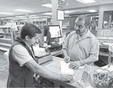  ?? JEFF AMY/AP ?? Juan Garcia, right, waits on a customer at his business, Hondumex, in downtown Morton, Mississipp­i, on Thursday.