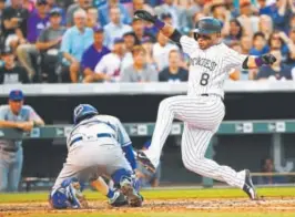  ?? Jack Dempsey, The Associated Press ?? The Rockies’ Gerardo Parra jumps to try to avoid the tag by New York Mets catcher Travis d’Arnaud during the third inning of Wednesday’s game at Coors Field. Parra was out on the play.