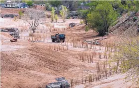  ?? EDDIE MOORE/JOURNAL ?? Constructi­on of a joint project between Santa Fe County and the city of Santa Fe continues near freshly planted willows. Workers are having to water the trees due to the lack of water in the Santa Fe River.