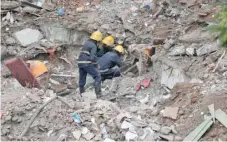  ?? — Reuters ?? Firefighte­rs remove debris as they search for survivors at the site of a collapsed building in the suburbs of Mumbai on Wednesday.