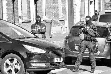  ??  ?? Police officers of an anti-terrorim unit and of French intelligen­ce agency (DGSI) patrol in a street on Wattignies, northern France, after a man was arrested during a French-Belgian anti-terrorist operation. — AFP photo