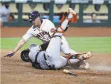  ?? Karen Warren / Hearst Newspapers ?? Astros outfielder Josh Reddick collides with Giants catcher Chadwick Tromp and is tagged out in the seventh inning.