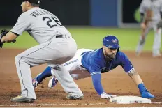  ??  ?? The Blue Jays’ Kevin Pillar dives back to first base on a pickoff attempt in the game against the Seattle Mariners at Rogers Centre in Toronto on Friday.