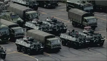  ?? AFP/Getty Images ?? MILITARY VEHICLES are amassed at a stadium in Shenzhen, China, near the border with Hong Kong.