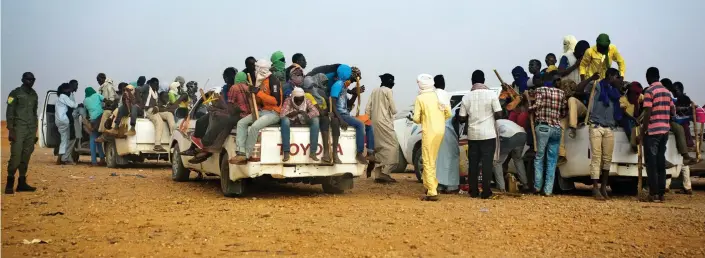  ??  ?? Heading north: Dozens of migrants are loaded on to trucks in Agadez, Niger. Tens of thousands are said to have died trying to cross Sahara since 2014