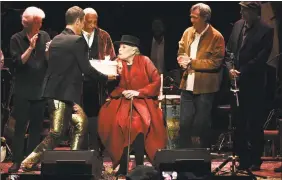  ??  ?? Joni Mitchell is presented with a birthday cake on stage at JONI 75: A Birthday Celebratio­n Wednesday at the Dorothy Chandler Pavilion in Los Angeles.