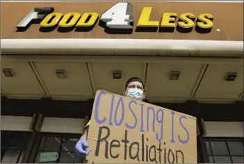  ?? Christina House Los Angeles Times ?? GROCERY CHAIN owner Kroger said Wednesday that it will close three stores in L.A. Above, Jose Rocha protests in February at a Food 4 Less in Long Beach that the company previously announced it would close.