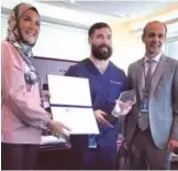  ??  ?? KUWAIT: Halah El Sherbini, Group Chief Human Resources and Developmen­t Officer at Burgan Bank Group honors Dr Timothy Simansky.