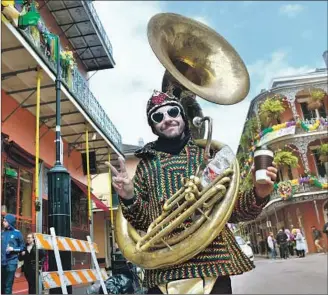  ??  ?? JASON JURZAK, wrapped in his sousaphone, heads off to perform on New Orleans’ Royal Street.