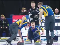  ?? Canadian Press photo ?? Mike McEwen, skip of the wild card team from Winnipeg, looks on as Alberta skip Brendan Bottcher, second Brad Thiessen, left, and lead Karrick Martin, right, bring a rock into the house at the Tim Hortons Brier curling championsh­ip in Regina on...
