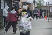  ?? Mel Melcon Los Angeles Times ?? ANGELO PADILLA, 12, carries food for him and his five siblings at San Fernando Senior High School.