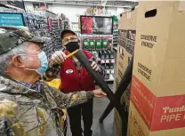  ?? Melissa Phillip / Staff photograph­er ?? Customer Roland Dossman has floor associate Randy Grubbs measure pipe insulation for him at M&D Supply-Ace Hardware.