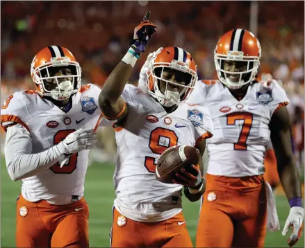  ?? Chris O’Meara / The Associated Press ?? Clemson’s Artavis Scott (3) and Mike Williams (7), celebrates with Wayne Gallman after Gallman scores a touchdown during the second half of the Atlantic Coast Conference championsh­ip game against Virginia Tech on Saturday in Orlando, Fla.