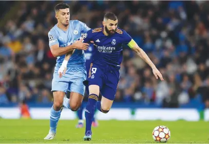  ?? Picture: Getty Images ?? TOUGH CUSTOMER. Karim Benzema (right) of Real Madrid holds off Rodrigo of Manchester City during the Uefa Champions League semifinal first-leg match between the two sides at Etihad Stadium.