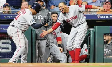  ?? ELSA / GETTY IMAGES ?? Mookie Betts (right) celebrates with Rafael Devers after Devers’ three-run homer in Game 5 of the ALCS. To keep slugger J.D. Martinez in the lineup, Betts may play second base in the World Series games at the NL city.