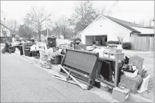  ?? KYLE KURLICK/SPECIAL TO THE COMMERCIAL APPEAL ?? Workers pile the contents of developer Michael Bourne’s Germantown home at the street after he was evicted Thursday morning.