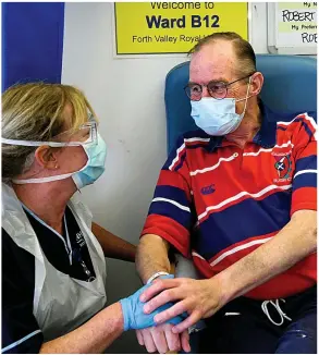 ??  ?? Caring nurse holds Covid patient Robin Bennie’s hand at Forth Valley Royal