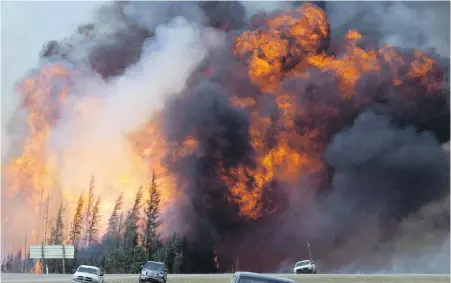  ??  ?? A giant fireball is seen as a wildfire rips through the forest by Highway 63, 16 kilometres south of Fort McMurray, Alta., on May 7, 2016. Nearly a year after the massive wildfire that devastated Fort McMurray, a climate scientist says there might be...