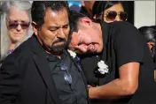  ?? RAY CHAVEZ — BAY AREA NEWS GROUP ?? As the hearse leaves, Alejandro Lopez, left, and his son Giovanni Lopez-Ruano mourn the death of Giovanni's godfather, Marciano Martinez, at Our Lady of the Pillar Catholic Church in Half Moon Bay. Martinez was one of seven farmworker­s killed in a mass shooting on Jan. 23, and his body will be sent to his native village in Oaxaca, Mexico, for burial.