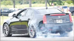  ?? Westside Eagle Observer/MIKE ECKELS ?? A Cadillac Hennessey performs a burnout as the driver begins his run down the runway at Crystal Lake Airport during the Exotic Experience Car Show in Decatur June 15.