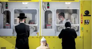  ?? (Nati Shohat/Flash90) ?? MEDICAL WORKERS from Magen David Adom test haredim for COVID-19 in Jerusalem’s Geula neighborho­od yesterday.