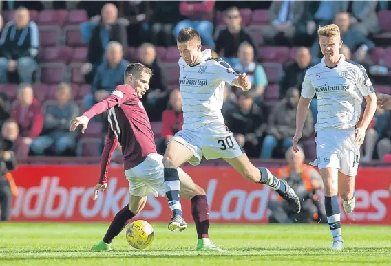  ??  ?? Dundee’s Cammy Kerr in the thick of the action at Tynecastle where the Dark Blues went down 1-0 at the weekend.