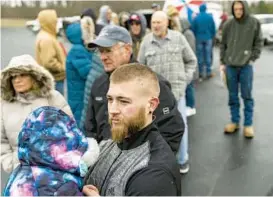  ?? MICHAEL SWENSEN/GETTY ?? Neil Figley holds his daughter Harlie as they wait in line Friday in East Palestine, Ohio. Figley and others were waiting to collect reimbursem­ent checks for expenses they incurred after they evacuated from the area surroundin­g a train derailment Feb. 3.