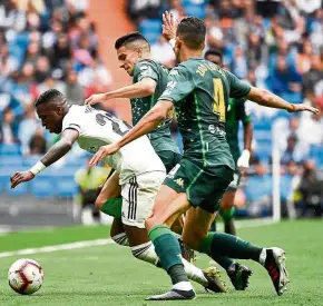  ?? —AFP ?? No way through: Real Madrid’s Vinicius Junior (left) is marked by Real Betis’ Marc Bartra (centre) and Zouhair Feddal during the La Liga match at the Bernabeu on Sunday.