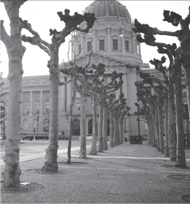  ?? Michael Short / The Chronicle 2014 ?? San Francisco: A person is seen sleeping on the ground at Civic Center Plaza in front of City Hall.