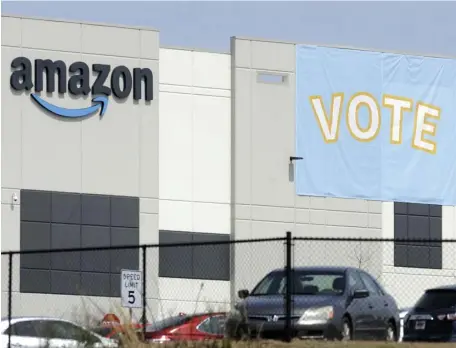  ?? AP FILE ?? REJECTED: A banner encouragin­g workers to vote in labor balloting is shown at an Amazon warehouse in Bessemer, Ala. Amazon workers voted against forming a union on Friday in Alabama.