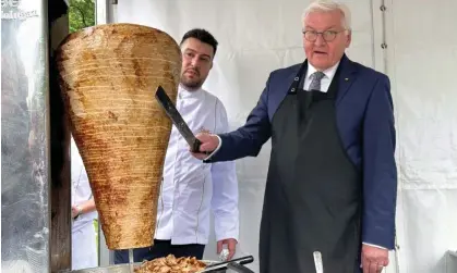  ?? Photograph: Anadolu/Getty Images ?? Steinmeier (right) had the skewer brought specially from Berlin, and included Arif Keleş, a third-generation snack shop owner, in his delegation.