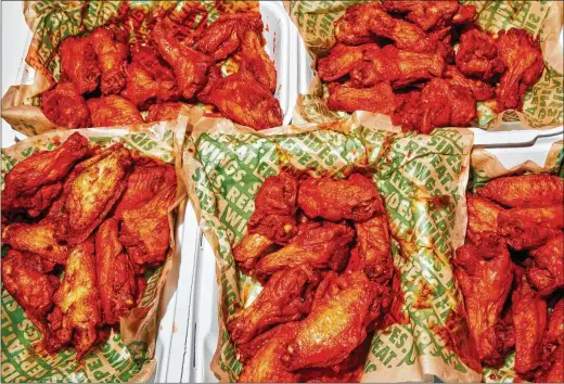  ?? PHOTOS BY AMY LOMBARD FOR THE NEW YORK TIMES ?? In Oklahoma City, an order of 50 bone-in wings from Wingstop that cost $41.99 early last year is now $47.49, a 13% increase. The pandemic has led to the largest price spikes at fast-food restaurant­s in two decades, according to government data.