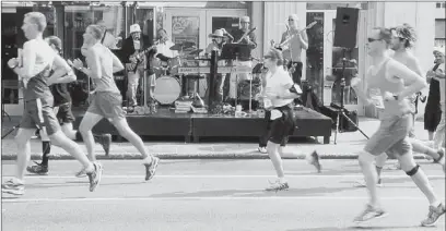  ?? Pam Panchak/post-gazette ?? Bob Scullion and the Mystics jam for the Pittsburgh marathoner­s Sunday along Liberty Avenue in Bloomfield.