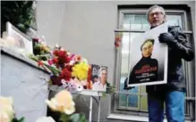  ??  ?? MOSCOW: A man holds a portrait of slain Russian journalist Anna Politkovsk­aya during a rally marking the 10th anniversar­y of her murder. — AFP