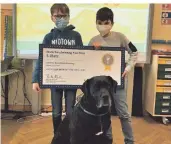  ?? FOTO: SCHULE ?? Jan Hennisge (li.) und Kiyan Ökce aus dem E-Twinning-Projekt zeigen stolz
die Urkunde für den dritten Platz. Mit dabei ist Schulhund
Emma.