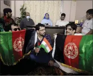  ??  ?? Afghan men hold Afghanista­n’s national flag on the occasion of the 102nd Afghanista­n Independen­ce Day, in Kolkata on Thursday. ANI