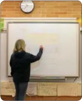  ??  ?? Holland Elementary School Humanities teacher Amy Smith demonstrat­es her new white board in a rebuilt classroom.