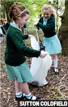  ?? ?? Helping hand: Girls from Holy Cross primary