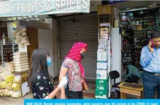  ??  ?? NEW DELHI: Women wearing facemasks, amid concerns over the spread of the COVID-19 novel coronaviru­s, walk in a market as they shop for groceries in New Delhi. —AFP