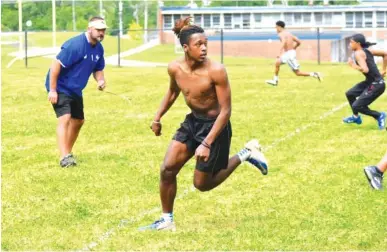  ?? STAFF PHOTOS BY PATRICK MACCOON ?? Red Bank High School’s OJ Jackson runs a route as coach Chris Brown looks on during Monday’s training session. Hamilton County schools resumed football practice for the first time since mid-March due to COVID-19.