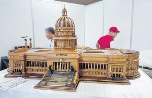 ?? AFP ?? Workers prepare a cigar humidifier with the image of Cuba’s National Capitol during the opening of the 22nd Cigar Festival at the Havana Convention Center on Monday.