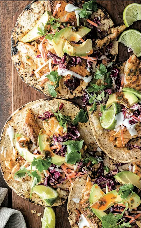  ?? Courtesy of Weldon Owen ?? Grilled Tilapia Tacos are topped with grilled radicchio slaw, homemade ranch dressing and fresh avocado.