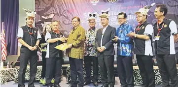  ??  ?? Antonio (front, second left) hands over the resolution­s to Abang Johari, witnessed by (from left) Dennis, Liwan, Gerawat, Lee, Chukpai and event organising chairman Dr Philip Raja look on.